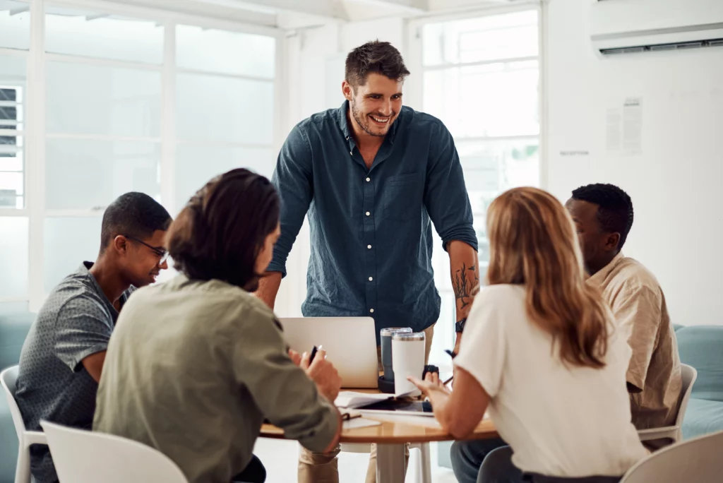 A manager conducting a team meeting around a small table