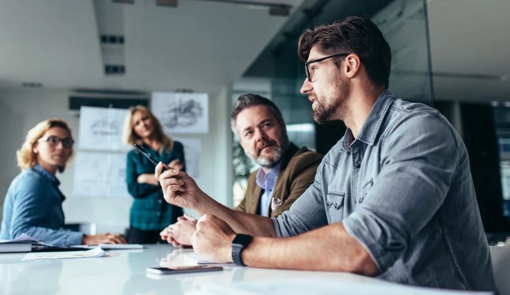 Man giving his ideas in a business meeting with three other people